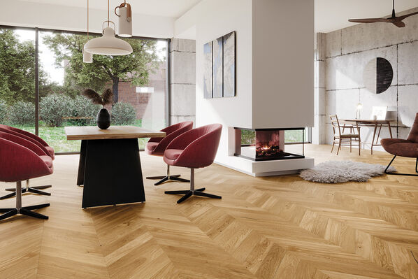 Wohnzimmer mit großer Fensterfront und Kamin und Parkettfußboden in Fischgrätoptik.